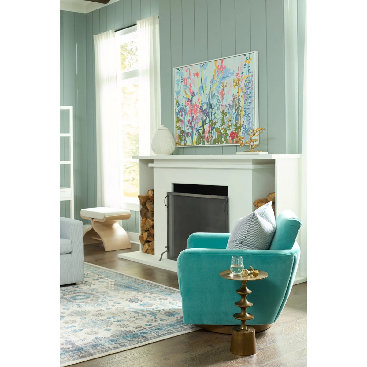 Harmon Small Accent Table by Villa & House — antique brass-finished aluminum table beside a teal chair in a living room