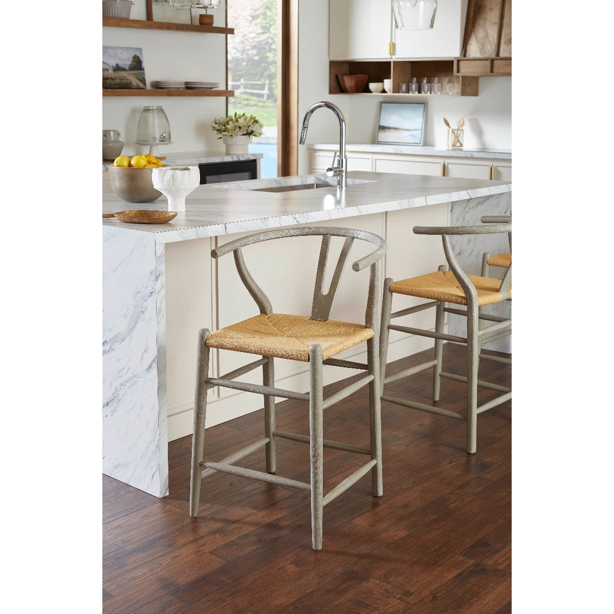 Oslo Counter Stools by Villa & House — gray-finished oak frames and woven rope seats at a marble kitchen island.