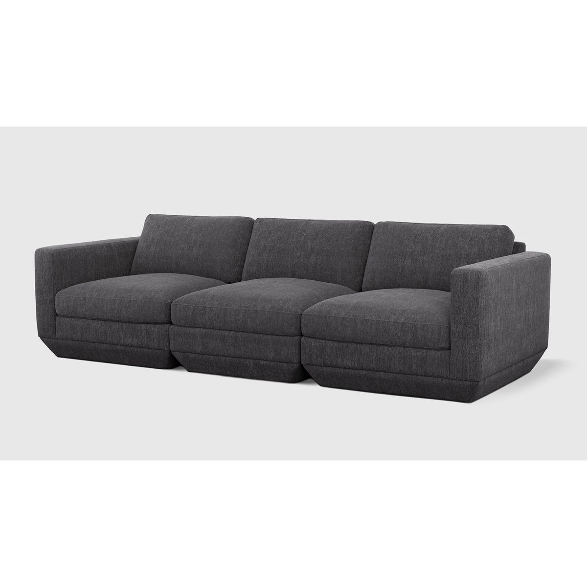 Podium Modular 3PC Sofa by Gus* — charcoal upholstery, angled view of three connected seating modules