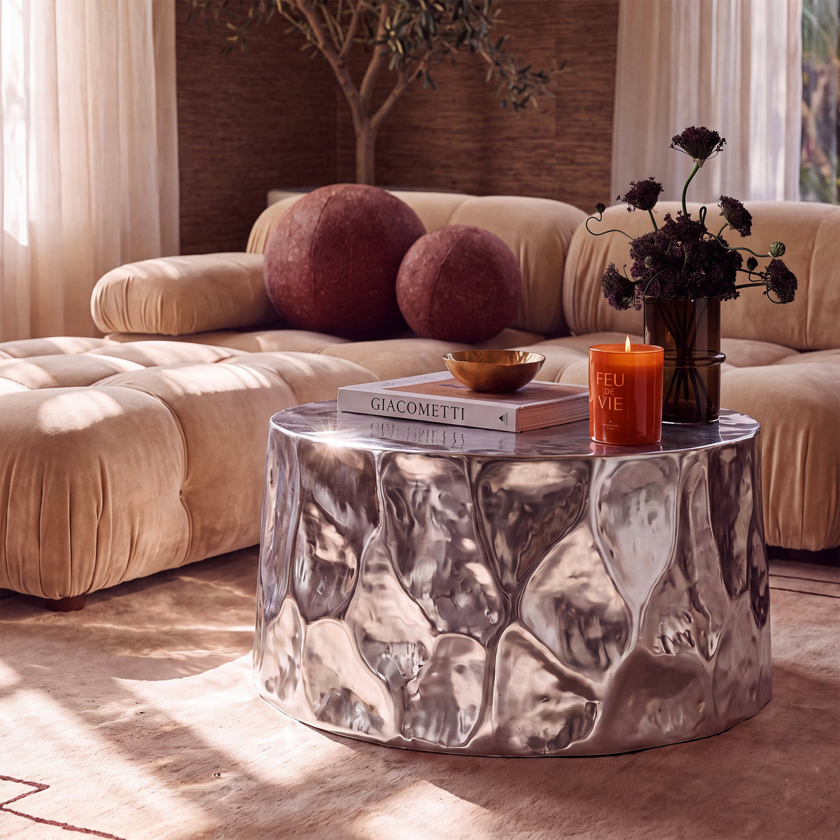 Forma 34" Chrome Coffee Table by TOV Furniture — wider living room view showing its reflective hammered surface.